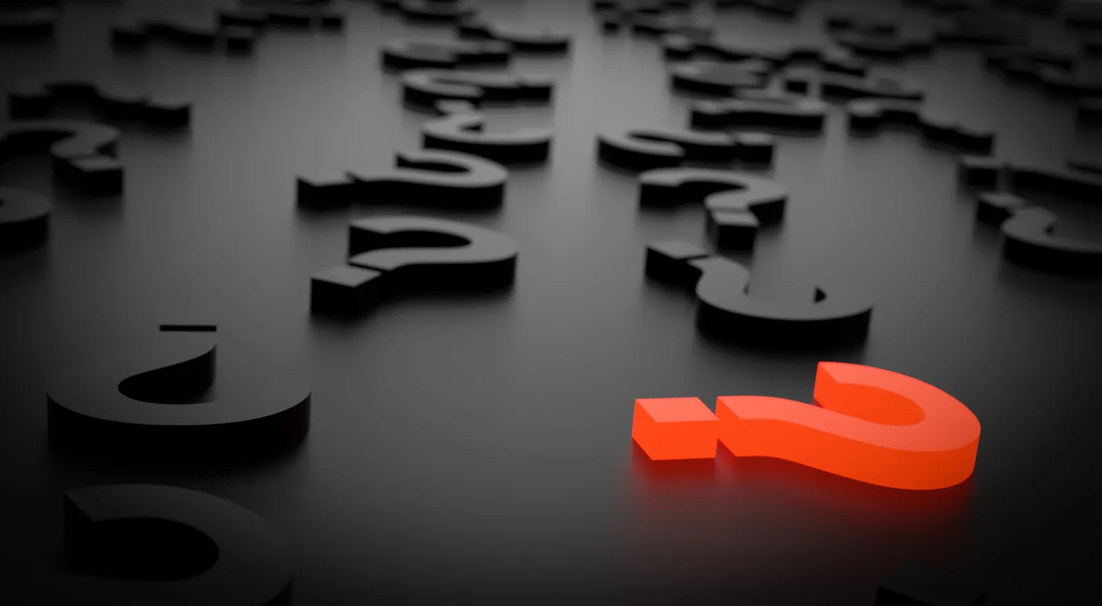 3d blocks shaped as question marks in black color with one in orange